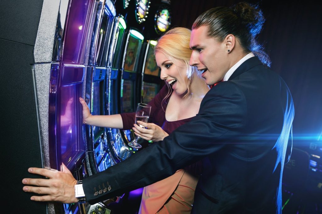 young-couple-playing-slot-machines-in-the-casino